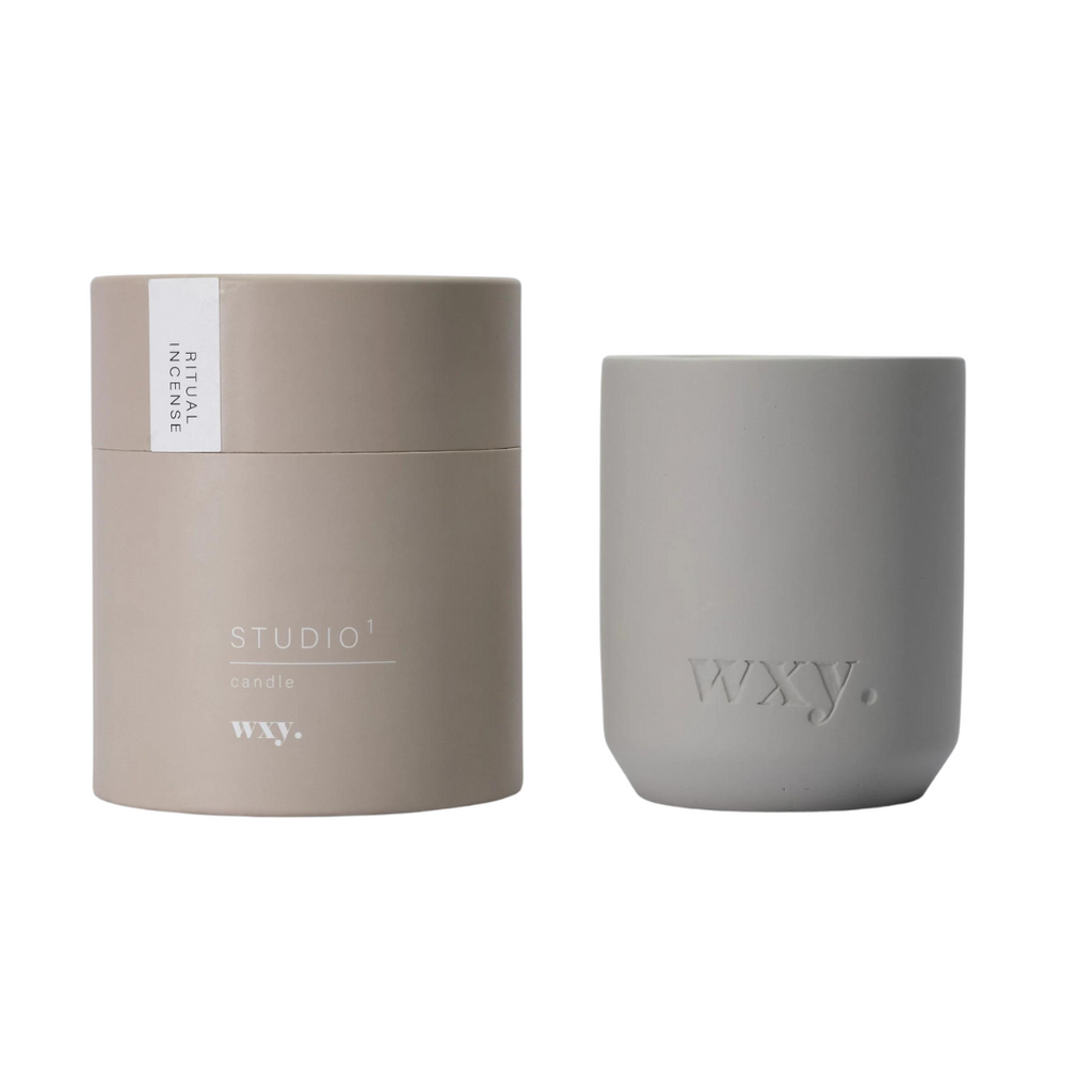 Wxy. Ritual Incense - Studio 1 Candle. Heart of oud, frankincense, cinnamon and pine with roses and white flowers. Accents of evergreen and a balsamic base of woods and musk.
