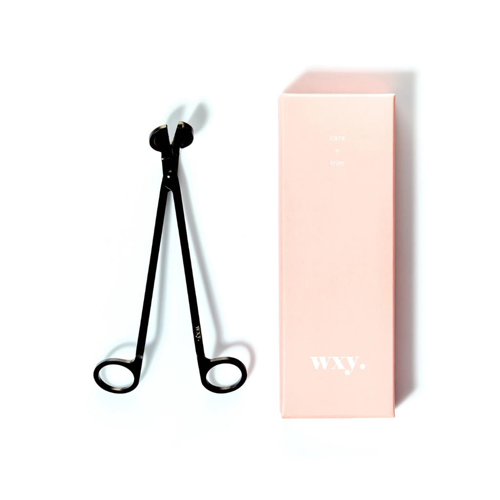 Wxy. Care + Trim. A sleek, matt black metal wick trimmer with discreet wxy. logo. A luxury pink box is included making this the perfect gift for candle lovers.