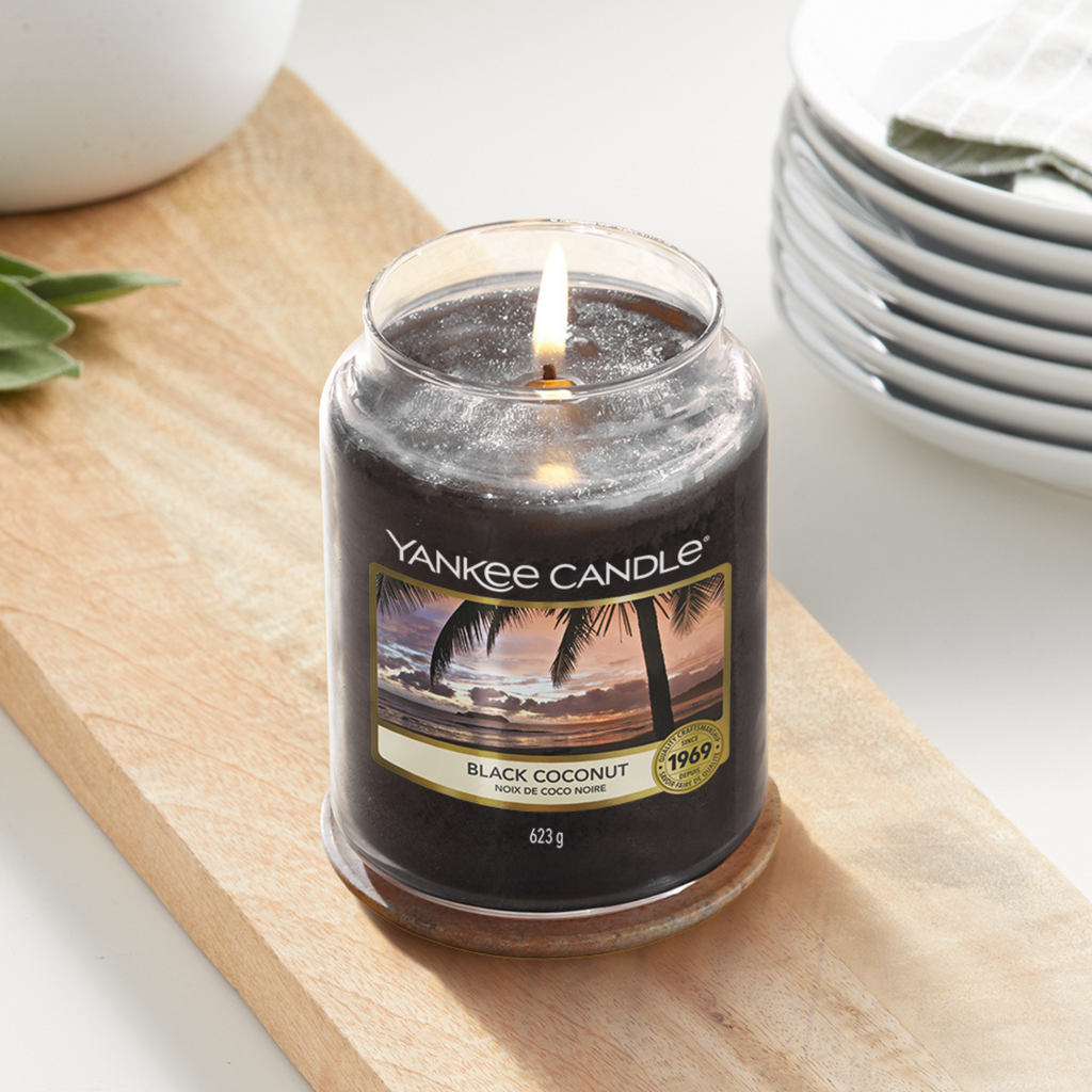 Yankee Candle Black Coconut Large Jar Candle. Notes of rich coconut, cedarwood and island blossoms promise a relaxing evening of luxurious calm tranquillity